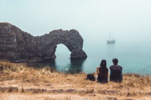 couple sat in front of durdle door