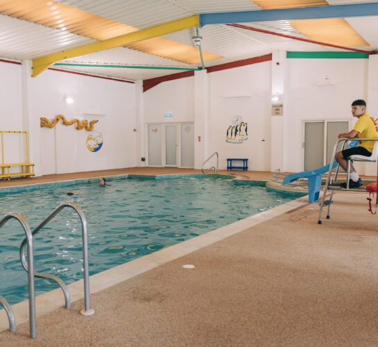 lifeguard overlooking indoor swimming pool ulwell